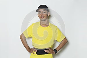 Young sporty man dressed in yellow tshirt on white background