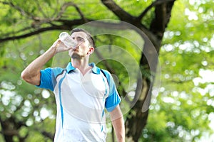 Young sporty man drinking mineral water