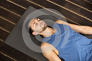 Young sporty man lying in Dead Body exercise