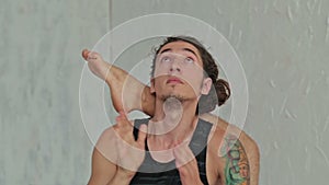 Young sporty man practicing ashtanga yoga in fitness studio