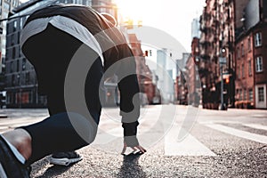 Young sporty man prepearing to start on urban running through on New York streets