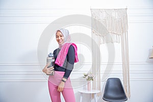 Young sporty muslim woman athlete in sportswear drinking water