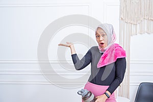 Young sporty muslim woman athlete in sportswear drinking water