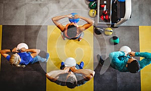 Young sporty people working out together with kettle bells in a gym.