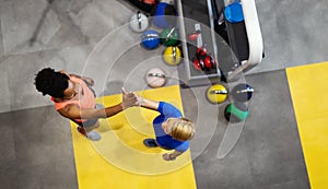 Young sporty people working out together with kettle bells in a gym.