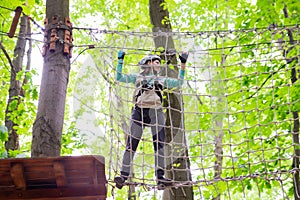 young sporty woman climbing in rope park