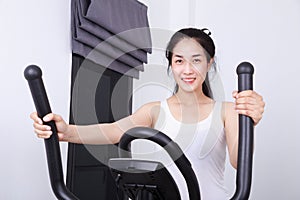 Sporty woman doing exercises with elliptical trainer