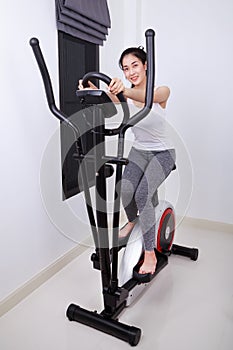 Sporty woman doing exercises with elliptical trainer