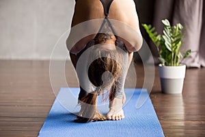 Young sporty woman doing head to knees exercise, close up