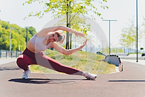 Young Sporty woman doing stretching exercise promenade.