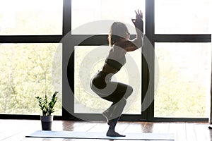 Young sporty woman doing yoga Eagle exercise