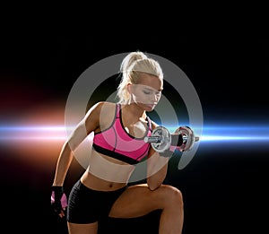 Young sporty woman with heavy steel dumbbell
