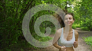 Young sporty woman jogging through the forest