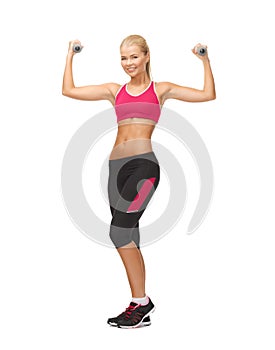 Young sporty woman with light dumbbells