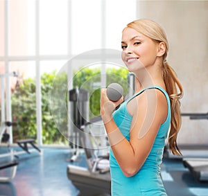 Young sporty woman with light dumbbells