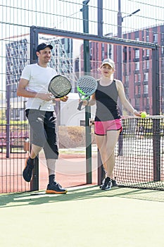 Young sporty woman and man playing padel together on same team