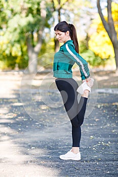 A young sporty woman with perfect body doing exercises outdoor.