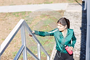 A young sporty woman with perfect body doing exercises on stairs outdoor.