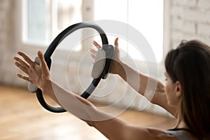 Young sporty woman practicing fitness exercise with a pilates ri