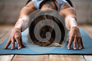 Young sporty woman practicing yoga, doing Balasana exercise, clo photo