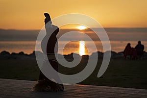 Young sporty woman practicing yoga, doing headstand exercise