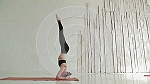 Young sporty woman practicing yoga in fitness studio