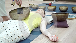 Young sporty woman practicing yoga lesson with instructor in gym