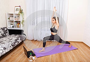 Young sporty woman practicing yoga. Woman working out at home.