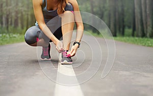 Young sporty woman preparing to run in early foggy morning in th