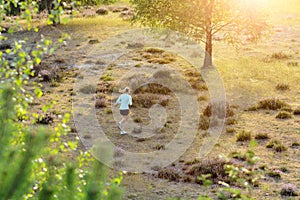 Young sporty woman in sportswear running cross-country outdoors in nature