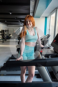 young sporty woman stand near racetrack at gym