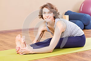 Young sporty woman stretching at gym