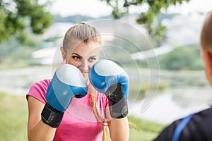 Young sporty woman training boxing with trainer