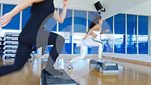 Young sporty women training the step aerobics in the gym