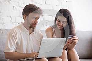 Young spouses making online shopping at home