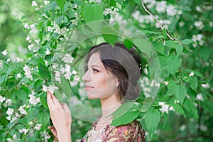 Young spring fashion woman in spring garden. Beautiful girl in spring landscape background. Allergic to pollen of flowers. Female
