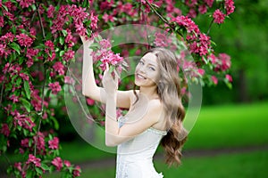 Young spring fashion woman in spring garden Springtime Summertime Trendy girl in the flowering trees in then at sunset in spring photo