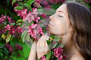 Young spring fashion woman in spring garden Springtime Summertime Trendy girl in the flowering trees in then at sunset in spring