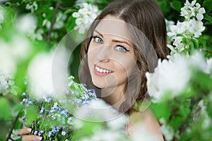 Young spring fashion woman in spring garden Springtime Summertime Trendy girl in the flowering trees in then at sunset in spring