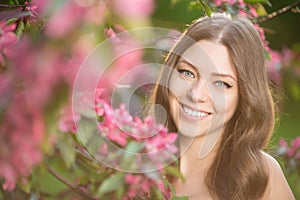 Young spring fashion woman in spring garden Springtime Summertime Trendy girl in the flowering trees in then at sunset in spring