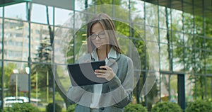 Young Startup Businesswoman using digital tablet. Beautiful woman in Glasses texting Messages, cheating on her digital