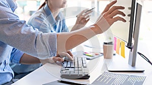Young startup Programmers Sitting At Desks Working On Computers screen for Developing programming and coding to find solution to