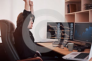 Young stock trader broker stretching hands at workplace, he first achieved great success on the stock market