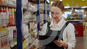 Young store manager writes products list in department