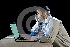 Young stressed businessman working on desk with computer laptop in frustration and depression