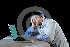 Young stressed businessman working on desk with computer laptop in frustration and depression