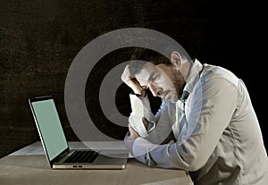Young stressed businessman working on desk with computer laptop in frustration and depression