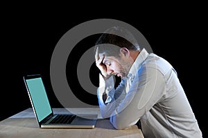 Young stressed businessman working on desk with computer laptop in frustration and depression