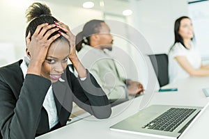 Young stressed businesswoman battling with a headache during a b