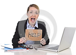 Young stressed businesswoman holding help sign overworked at office computer